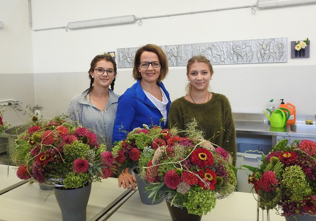 Landesrätin Christiane Teschl-Hofmeister (Bildmitte) mit zwei Schülerinnen in der neu errichteten Werkshalle der Landesberufsschule Langenlois