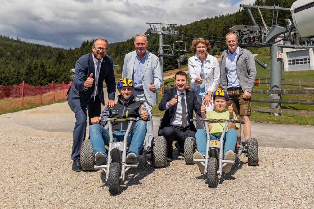 (v.l.n.r.): stehend: ecoplus Prokurist Bernhard Ebner, Bürgermeister Mönichkirchen Andreas Graf, Bezirkshauptfrau Neunkirchen Alexandra Grabner-Fritz, Geschäftsführer ecoplus Alpin Markus Redl; sitzend: Geschäftsführer Erlebnisalm Mönichkirchen Ralf Eisenhut, ecoplus Aufsichtsratsvorsitzender KO Kurt Hackl und ein begeisterter Mountaincart-Fahrer